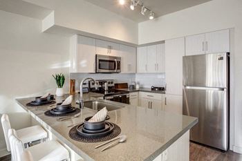 A modern kitchen with stainless steel appliances and granite counter tops